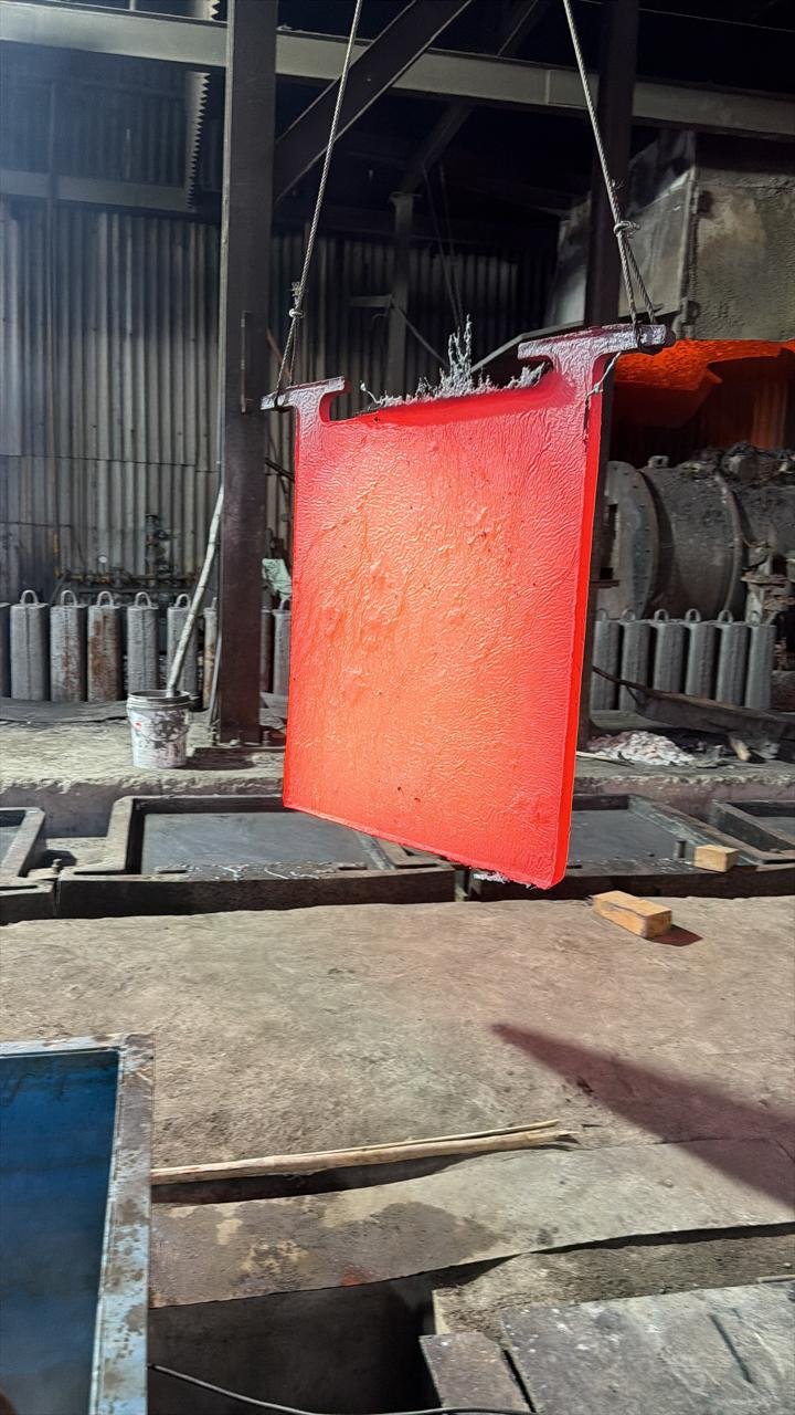A freshly cast, red-hot copper anode lifted from its mould